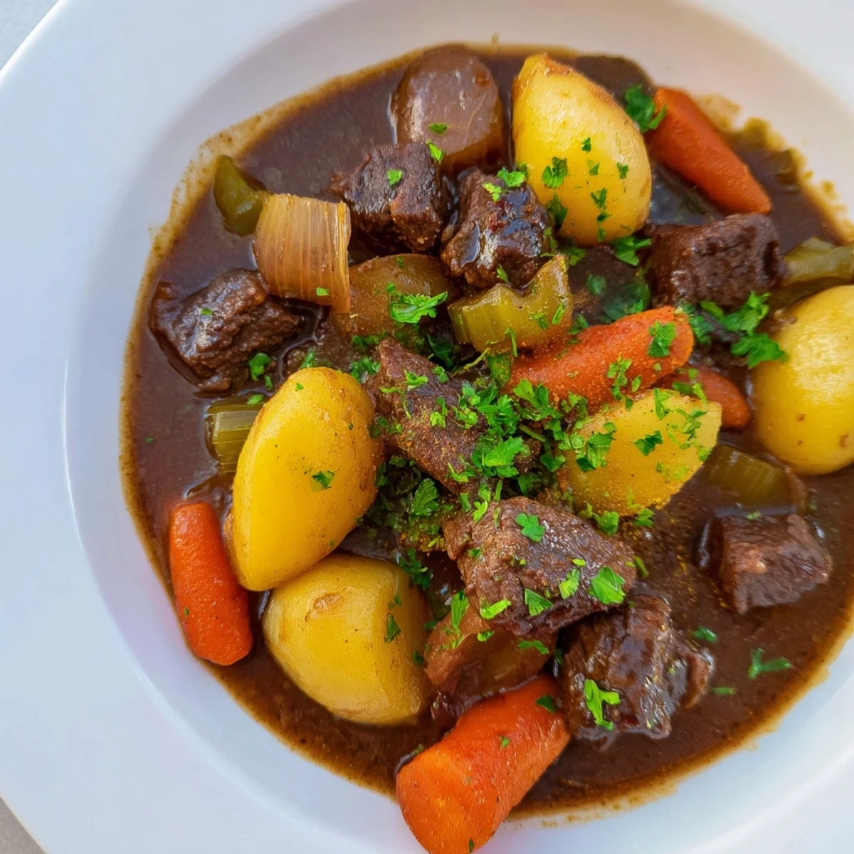 A steaming bowl of Irish Beef Stew, with tender beef and vegetables in a rich broth.