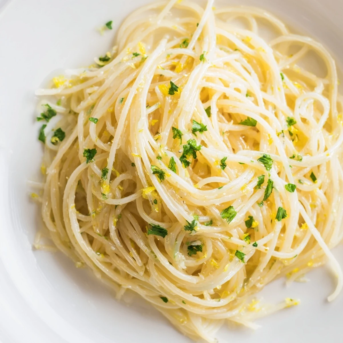 Lemon Butter Pasta Light on a white plate, garnished with fresh parsley and lemon zest.