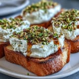 Velvety whipped ricotta toast with golden honey drizzled and nuts.