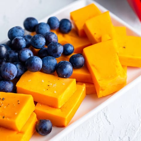 Vibrant Bauhaus Block appetizer featuring yellow cheddar, blue grapes, and red bell pepper artfully displayed.