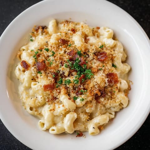 Close-up shot shows creamy, indulgent Tinis Mac and Cheese with Bacon topped with crispy bacon pieces.