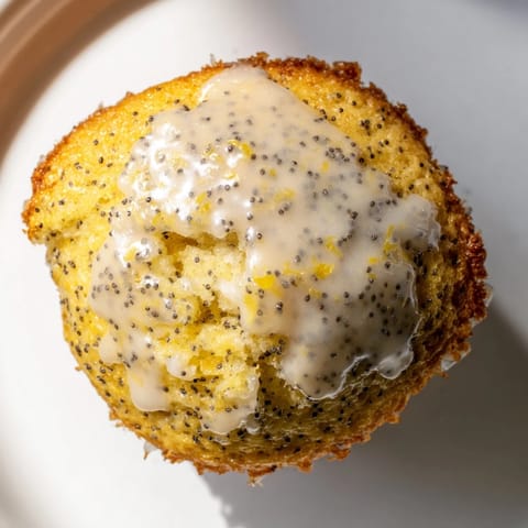 Warm, golden-brown Lemon Poppy Seed Muffins fresh from the oven, offering a delightful aroma and taste.