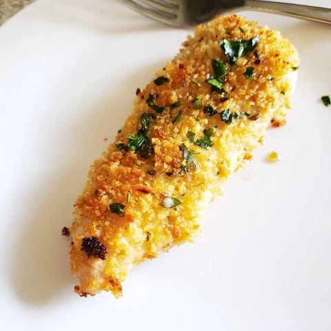 Savory garlic butter and Parmesan crusted chicken breasts served hot alongside a crisp green salad and lemon wedges.