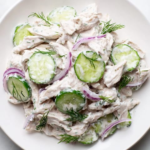 Plated Creamy Cucumber Chicken Salad garnished with fresh dill and green onions, served over crisp lettuce cups.