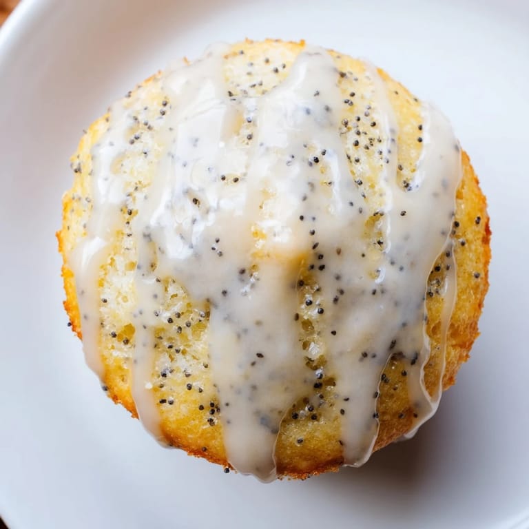 Enjoy a stack of homemade Lemon Poppy Seed Muffins, their bright citrus flavor making a perfect snack.