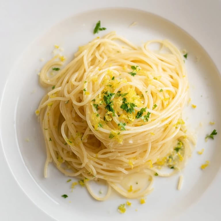 A close-up of Lemon Butter Pasta Light twirled on a fork, showcasing its silky, buttery texture.