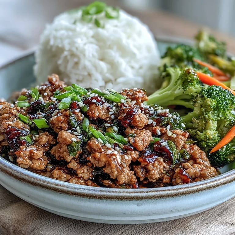 Steamed white rice serves as the base for Korean-Style Ground Turkey, topped with fresh chives and toasted sesame seeds.