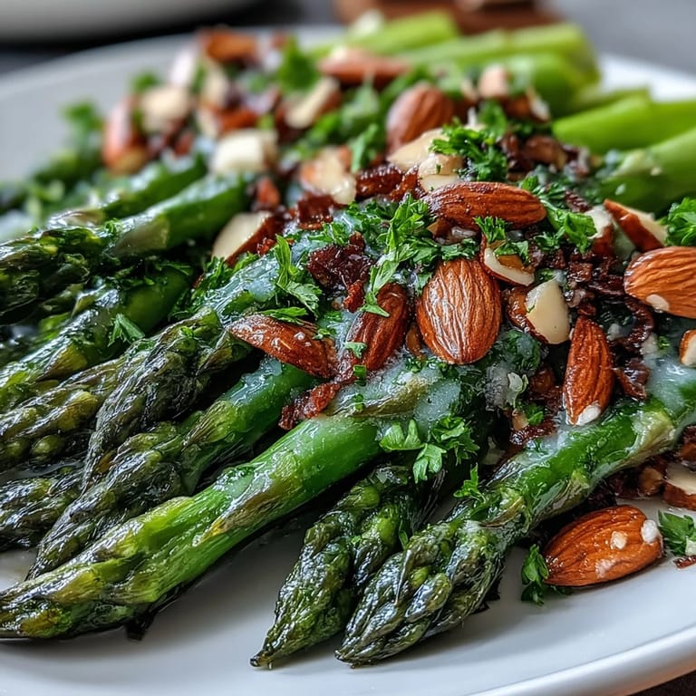 Tender asparagus sautéed in zesty lemon butter, topped with crunchy almonds for a vibrant, easy vegetarian recipe.